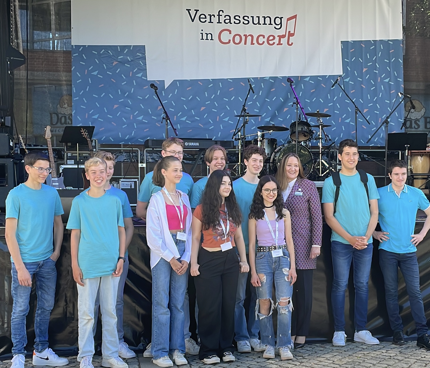 Die ebs-Band steht mit der Präsidentin des Landtages vor einer Bühne.